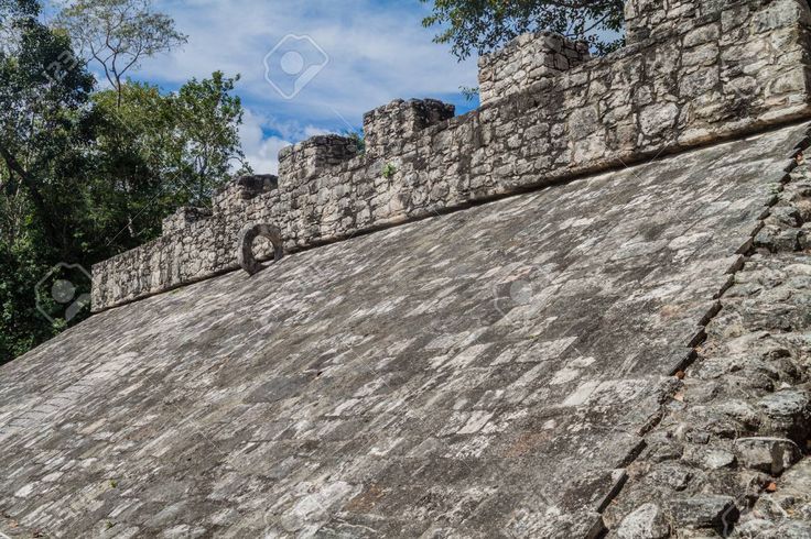 an old stone structure with trees in the background