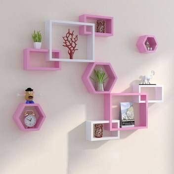 pink and white shelving unit with various items on it's shelves in the shape of hexagons