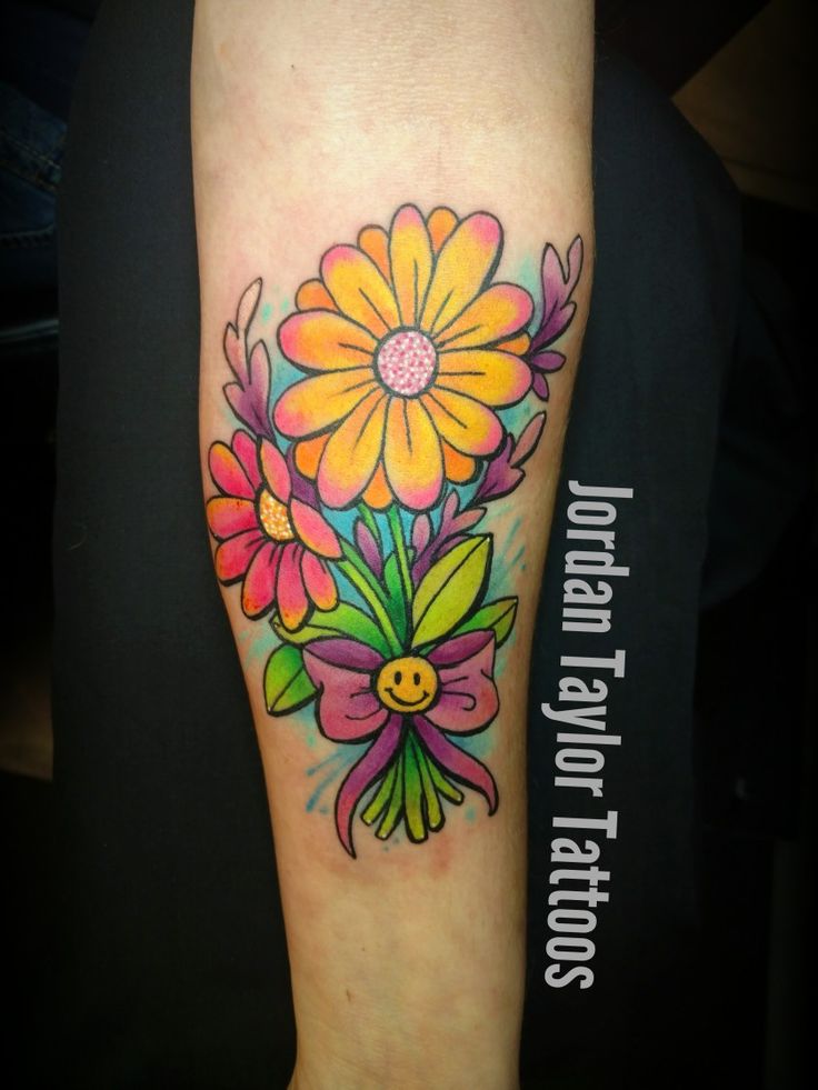 a colorful flower tattoo on the arm