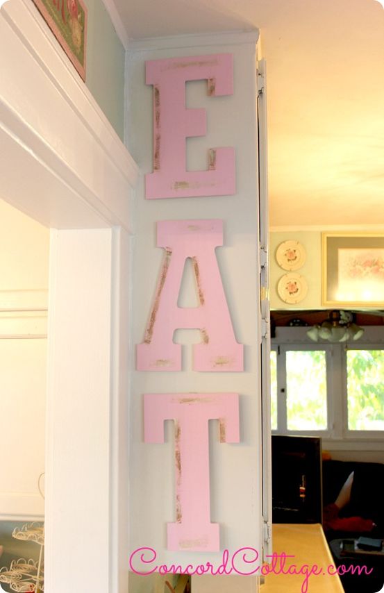 the letters are painted pink and white on the wall