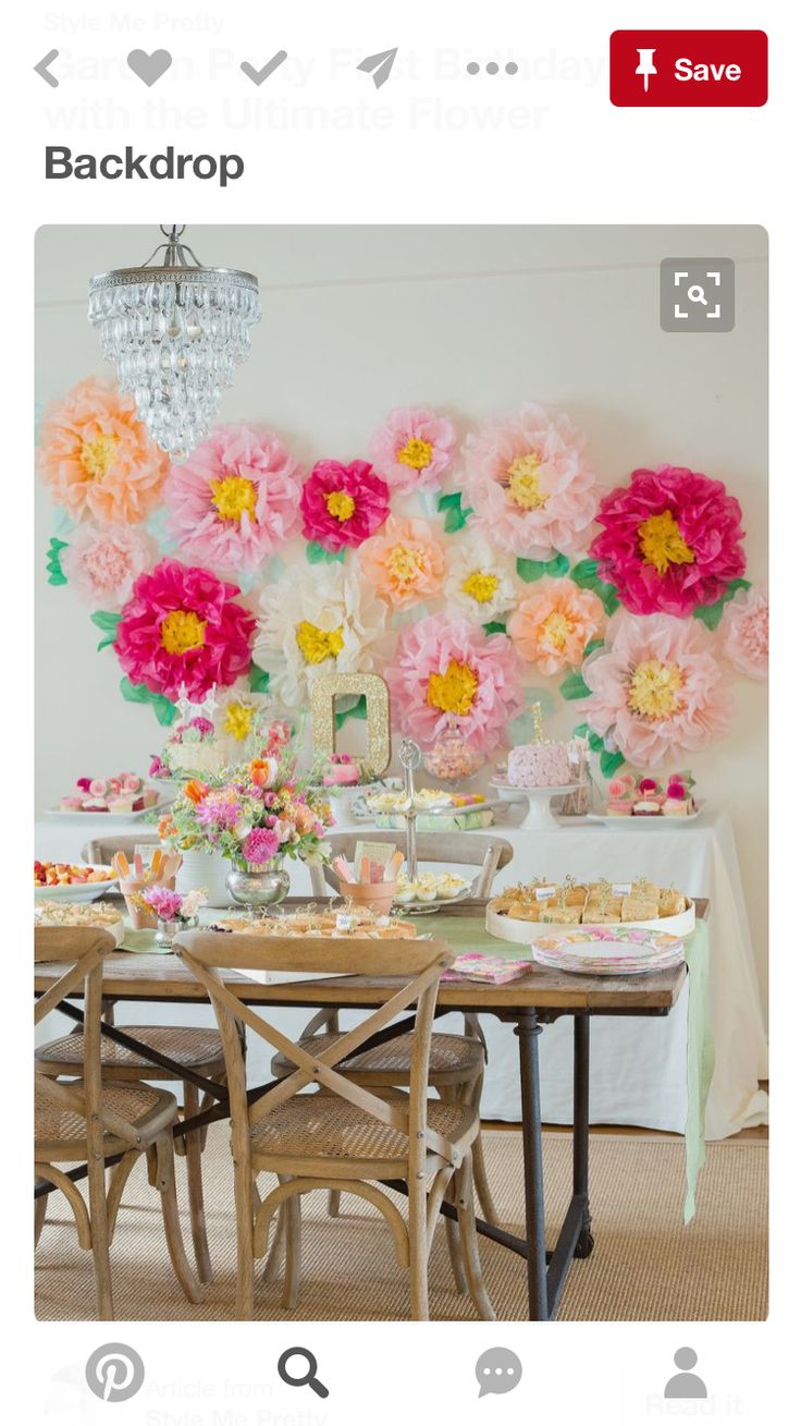 an image of a table with flowers on the wall and plates in front of it