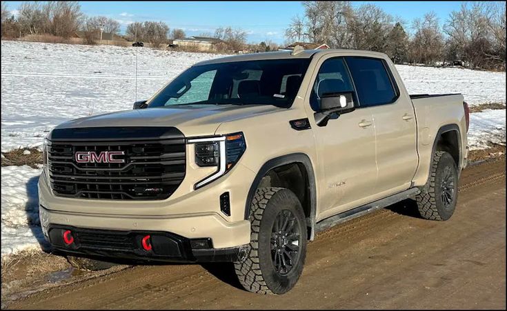 a white truck parked on the side of a road in front of snow covered ground