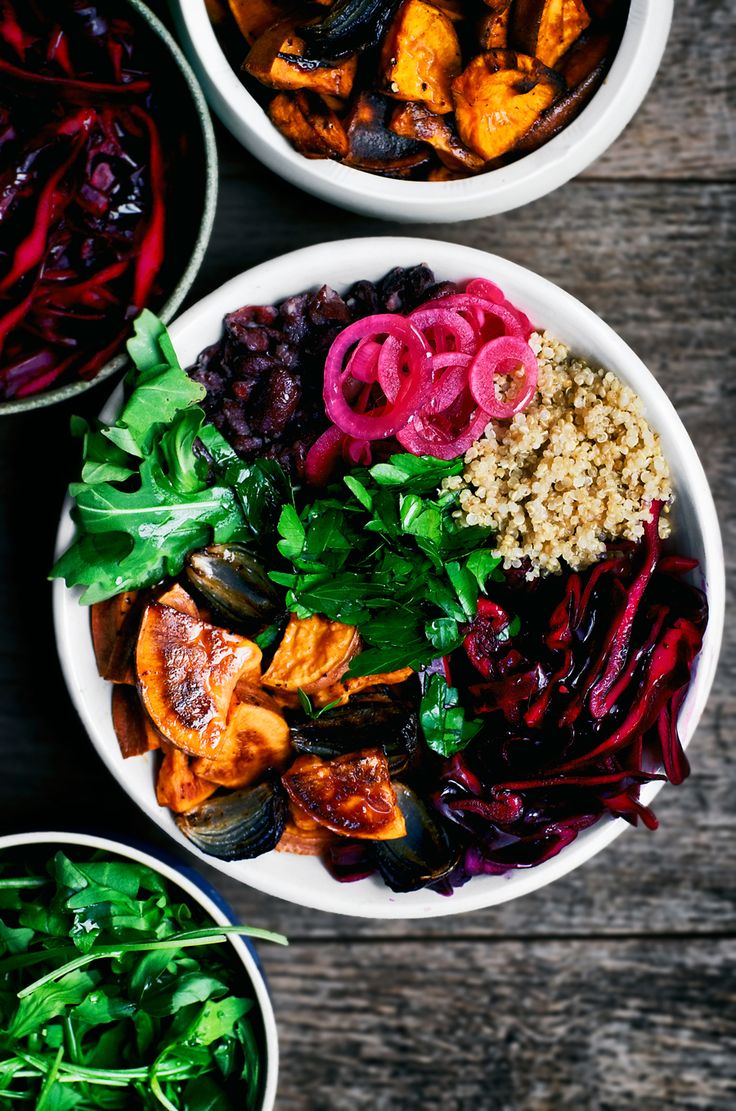 three bowls filled with different types of food on top of a wooden table next to each other