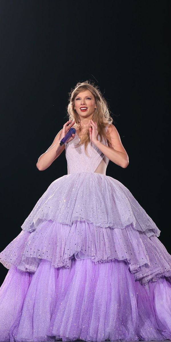 a woman in a long purple dress on stage