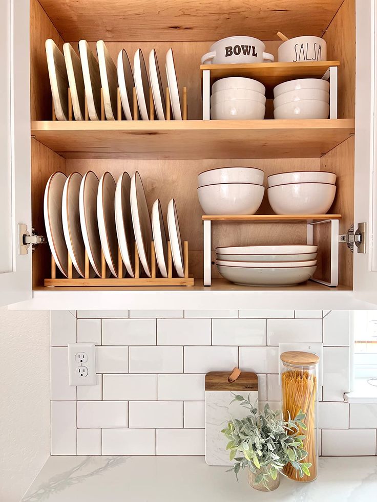 a kitchen cabinet filled with plates and bowls