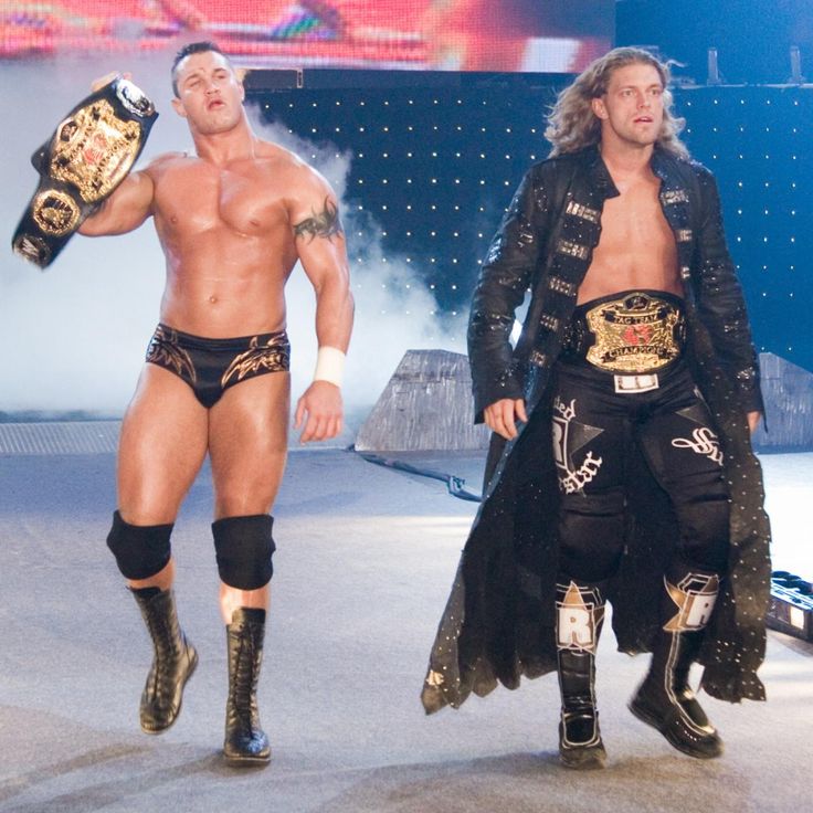 two men standing next to each other in wrestling gear