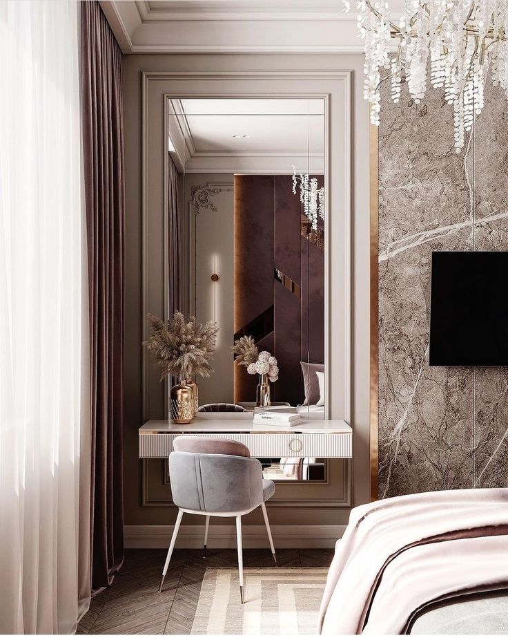 a bedroom with a vanity, mirror and chandelier hanging from the ceiling next to a bed