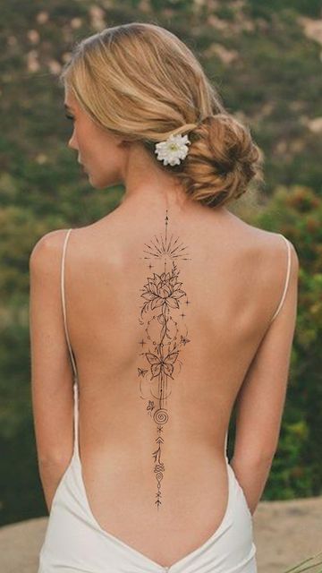 the back of a woman's body with tattoos on her upper and lower back