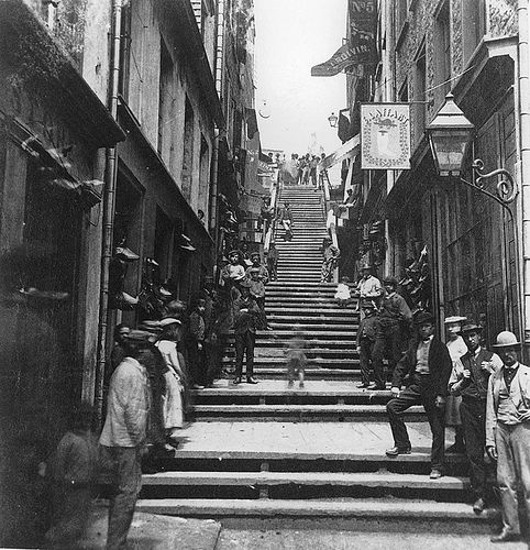 an old black and white photo of people walking up stairs