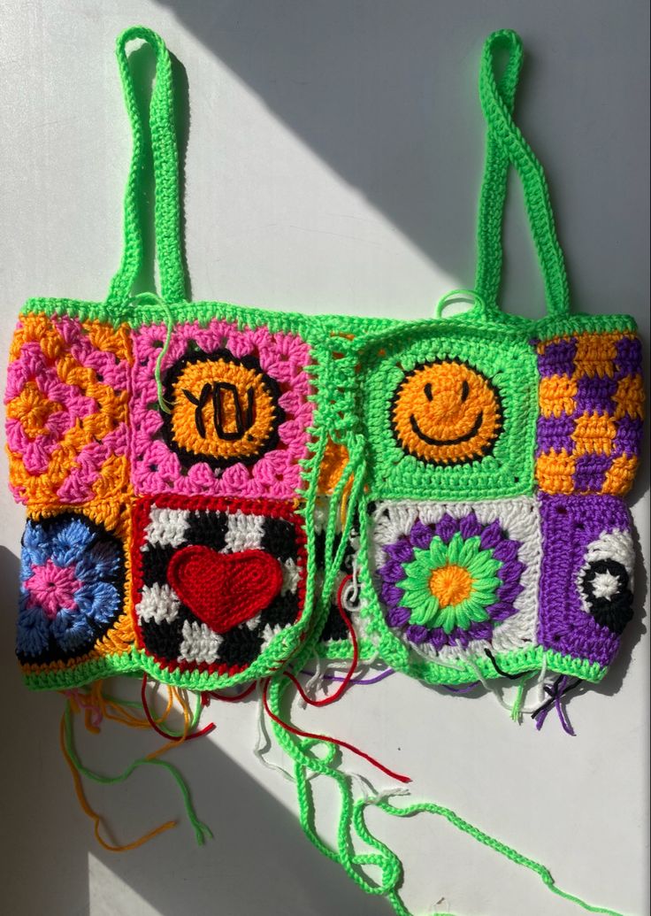 two crocheted purses are hanging on the wall