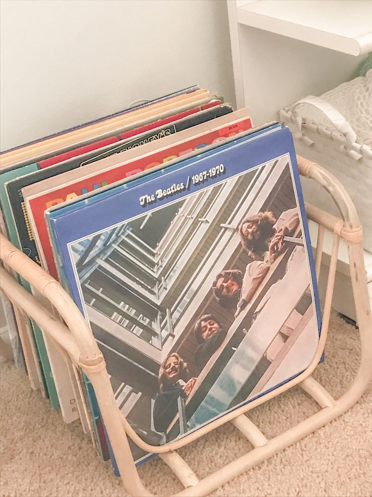 a stack of records sitting on top of a wooden rack