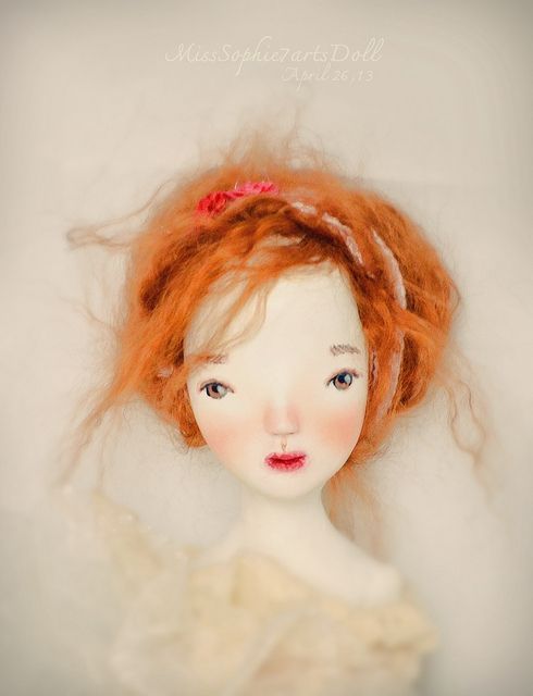 a doll with red hair wearing a white dress