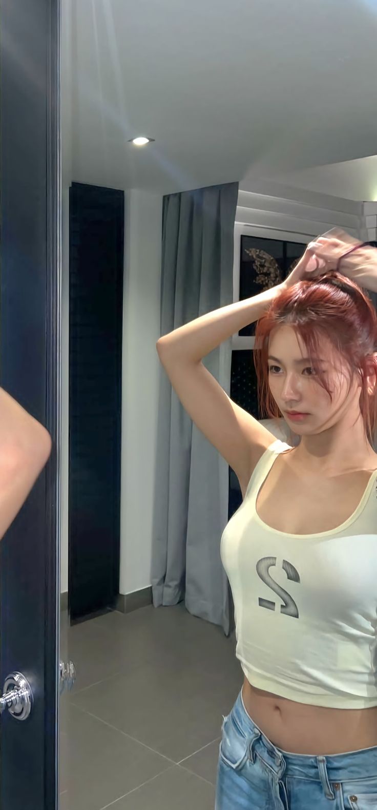 a woman with red hair is standing in front of a mirror