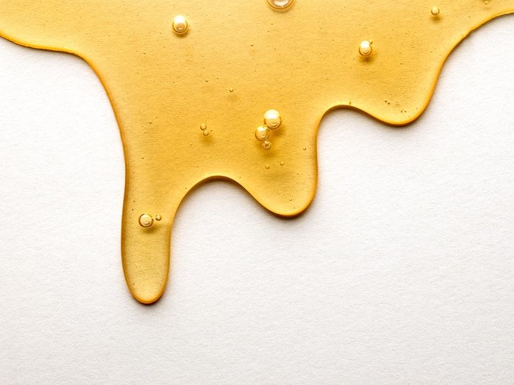 melted yellow paint with drops of water on white background by stocksystocker for stocksy stock