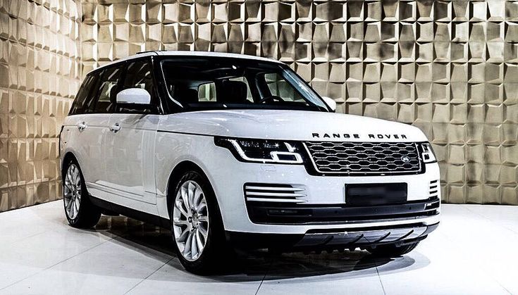 a white range rover parked in front of a wall