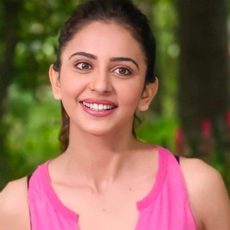 a woman in a pink top smiling for the camera