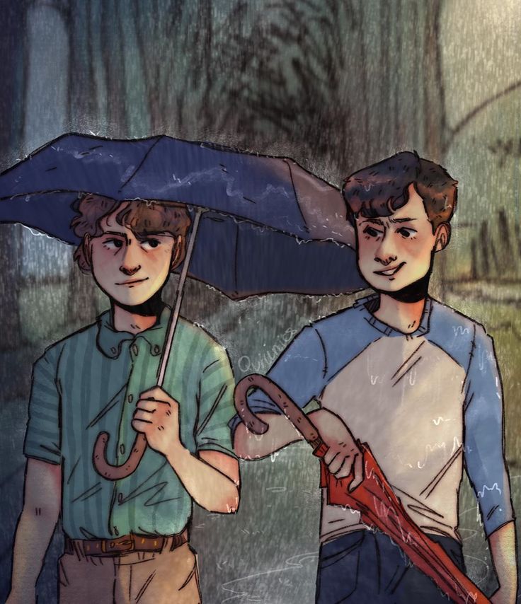 two young men standing under an umbrella in the rain