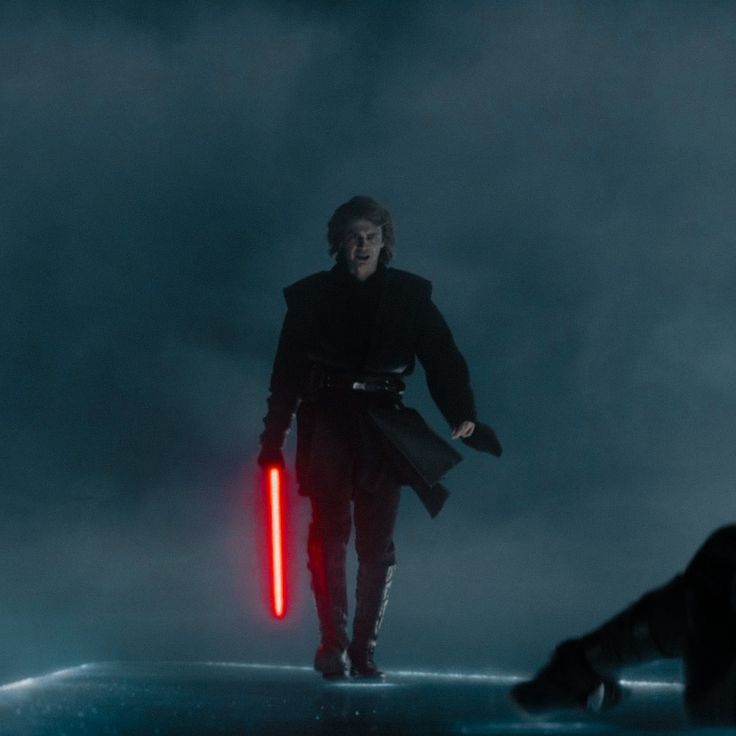 a man holding a red light saber in his right hand and walking away from the camera