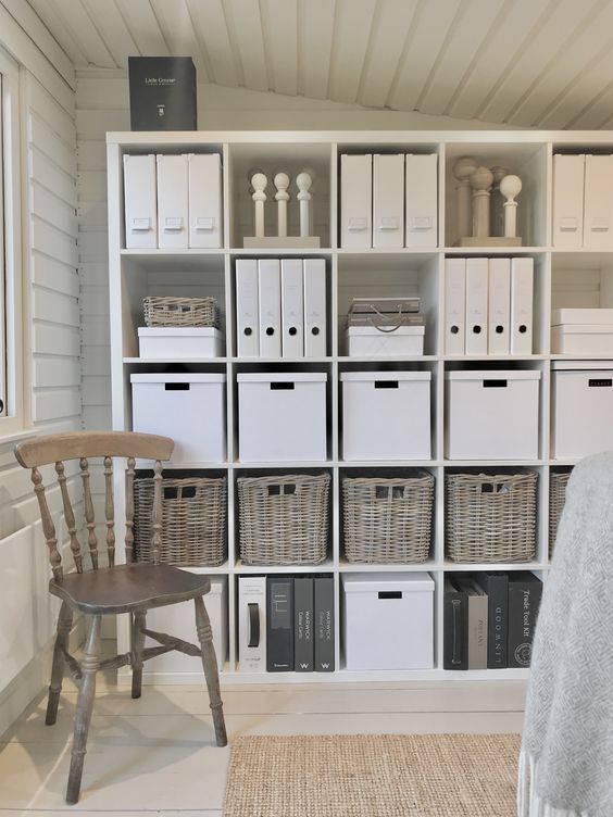 a room filled with lots of white boxes and baskets on top of eachother