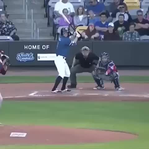 This may contain: a baseball player throwing a ball to another player on the field while people watch from the bleachers