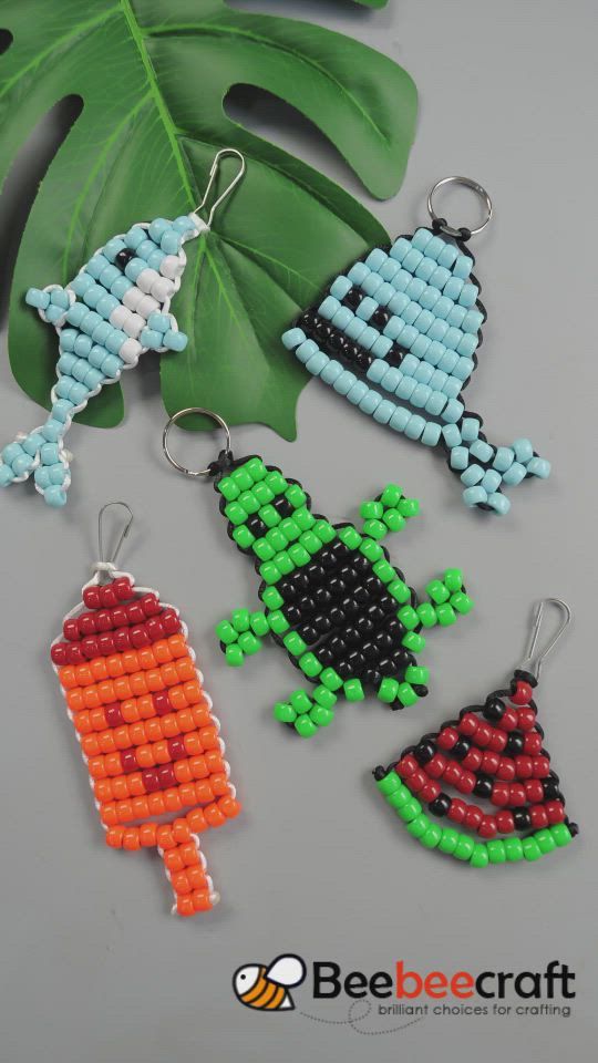 This may contain: beaded keychains with different designs on them and a green leaf in the background