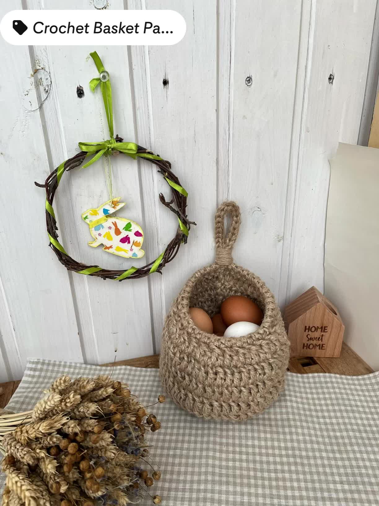 This may contain: a basket with eggs in it next to a wreath and other items on a table