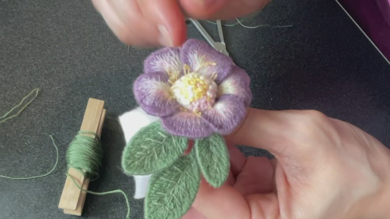 This may contain: someone is making a flower out of yarn