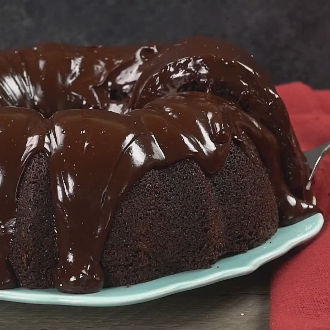 This may contain: a piece of chocolate bundt cake on a plate with a fork