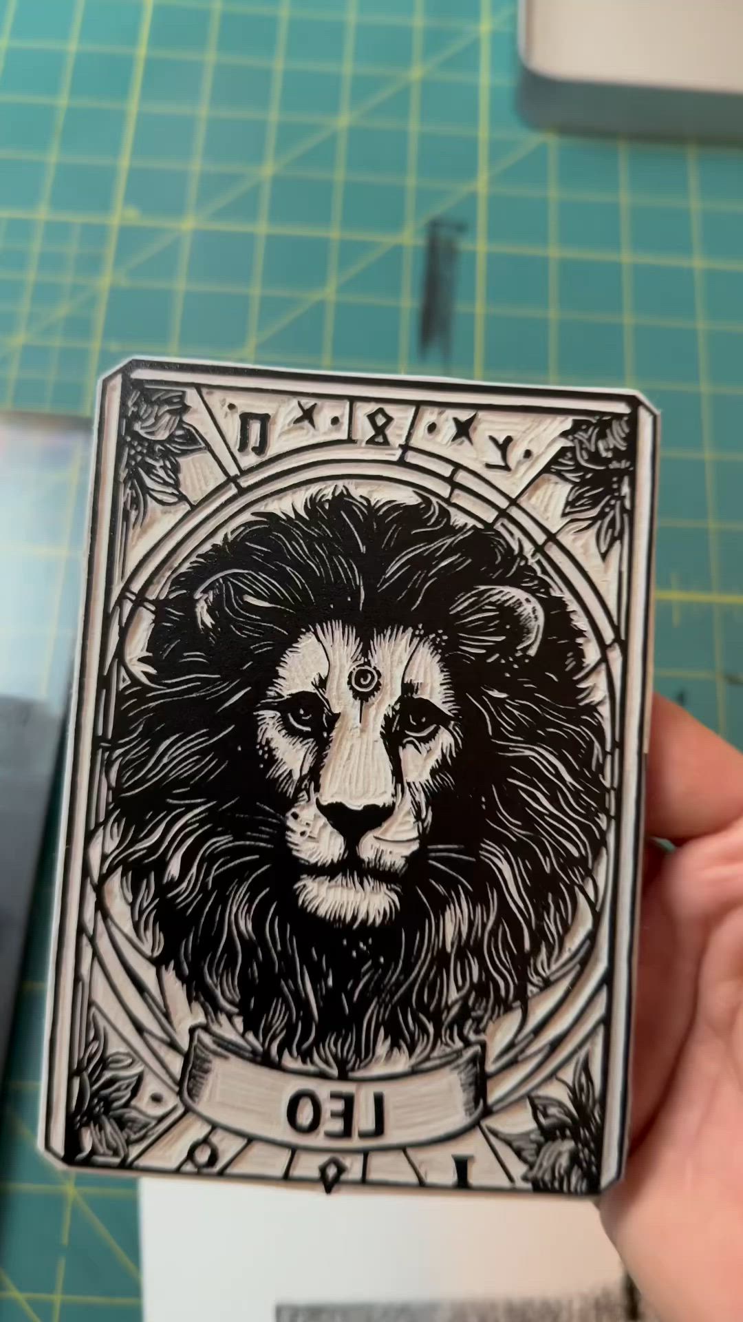 This may contain: a person holding up a card with a lion on it