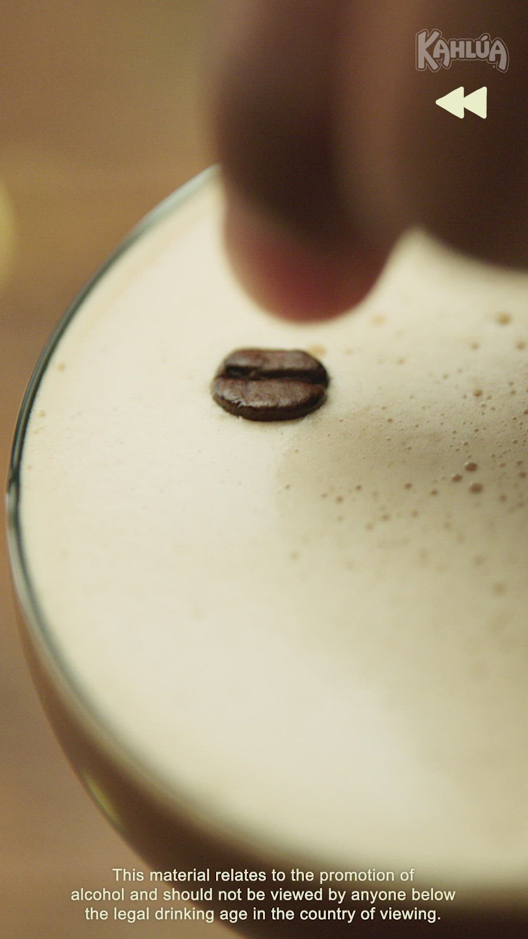 This may contain: a close up of a coffee cup with a person's hand touching the top