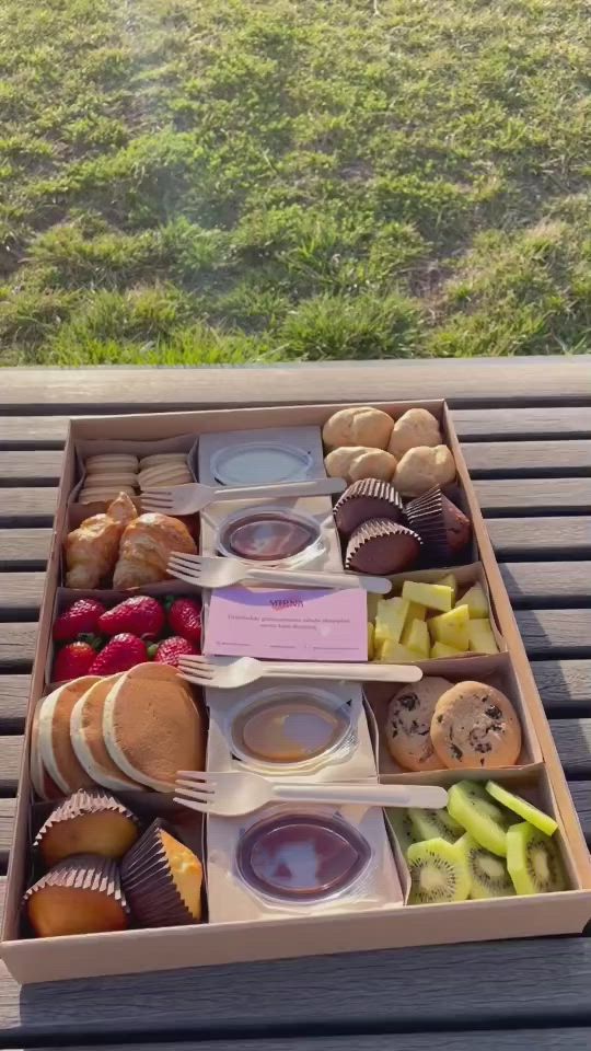 This may contain: an open box filled with lots of different types of food on top of a wooden table