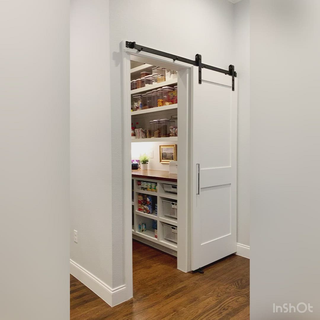 This may contain: an open pantry door in a white kitchen