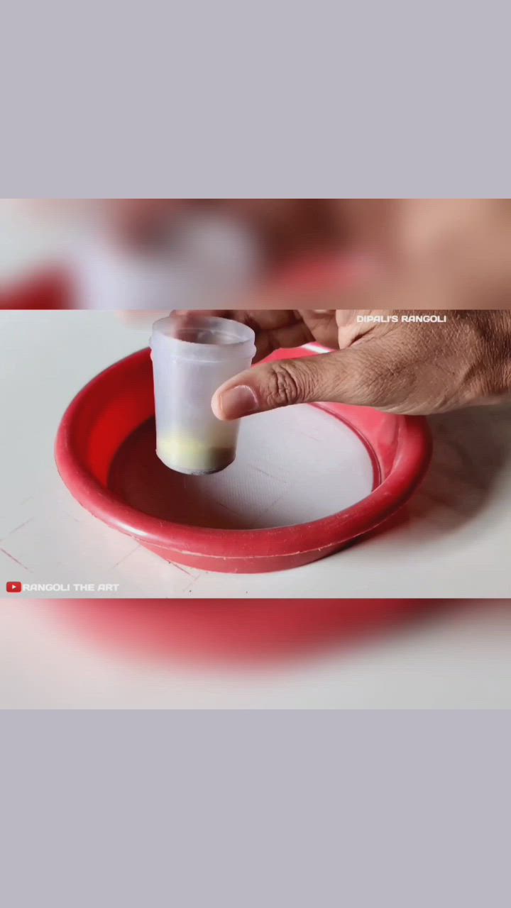 This may contain: a person holding a cup in their hand on top of a red saucer and white plate