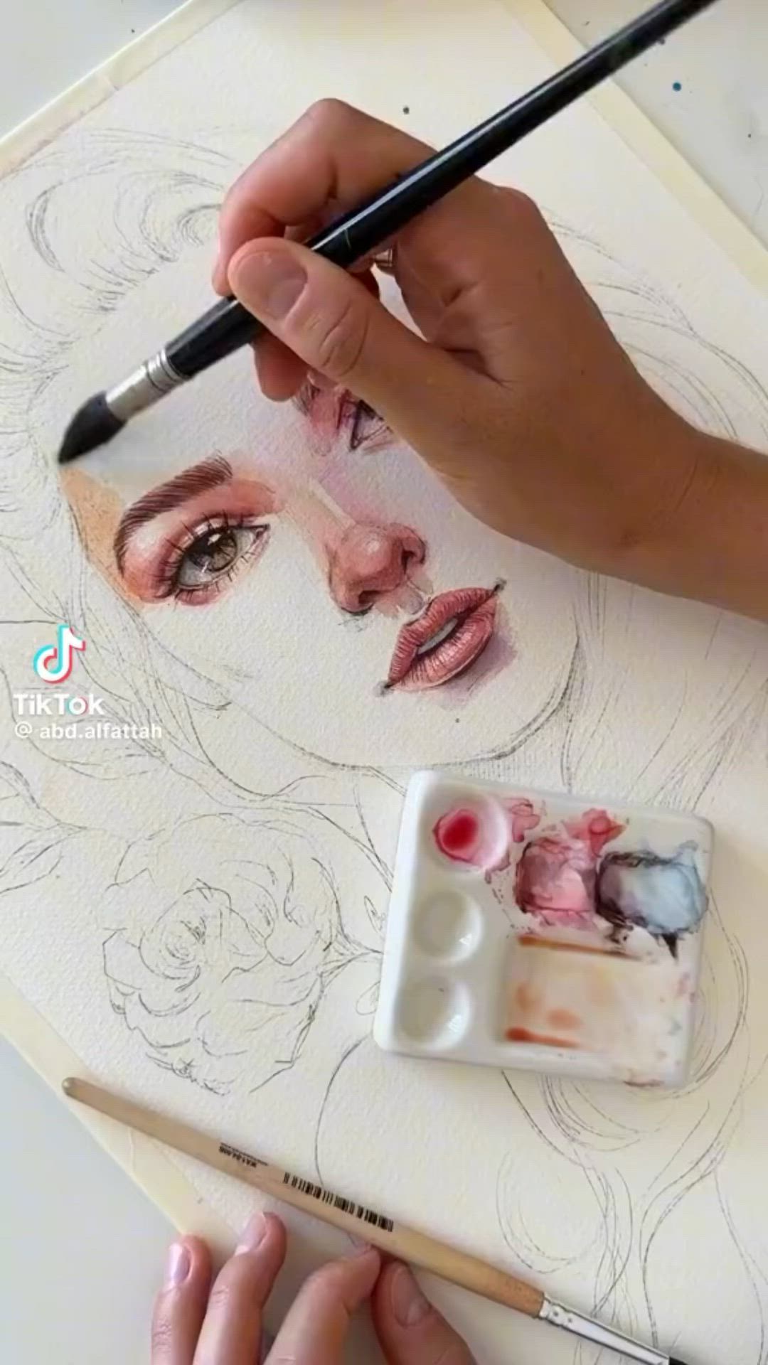 This may contain: a person is drawing on a piece of paper with a brush and watercolor pencils