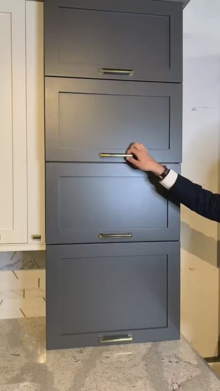 This may contain: a man in a suit is opening the drawer with his hand and pointing at it