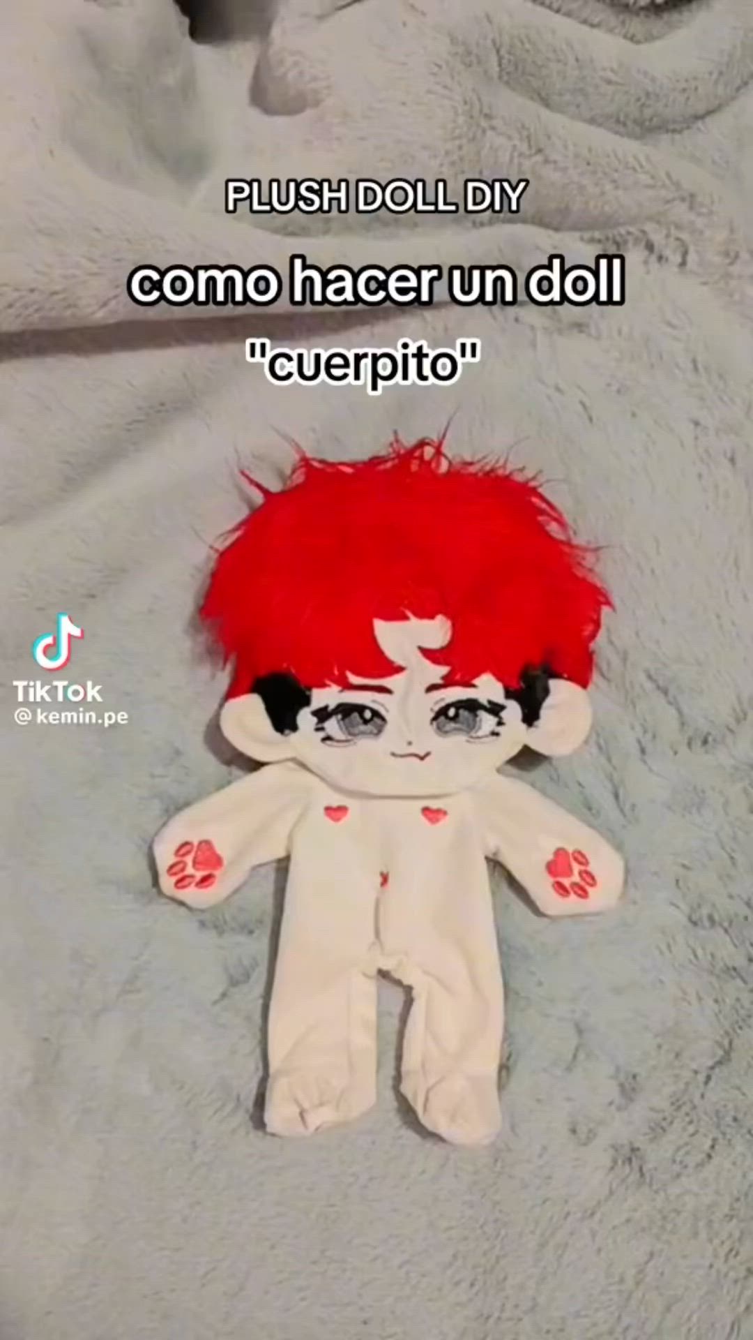 This may contain: a stuffed animal with red hair on top of a white blanket and the words flush doll diy como hacer un doll cerepito