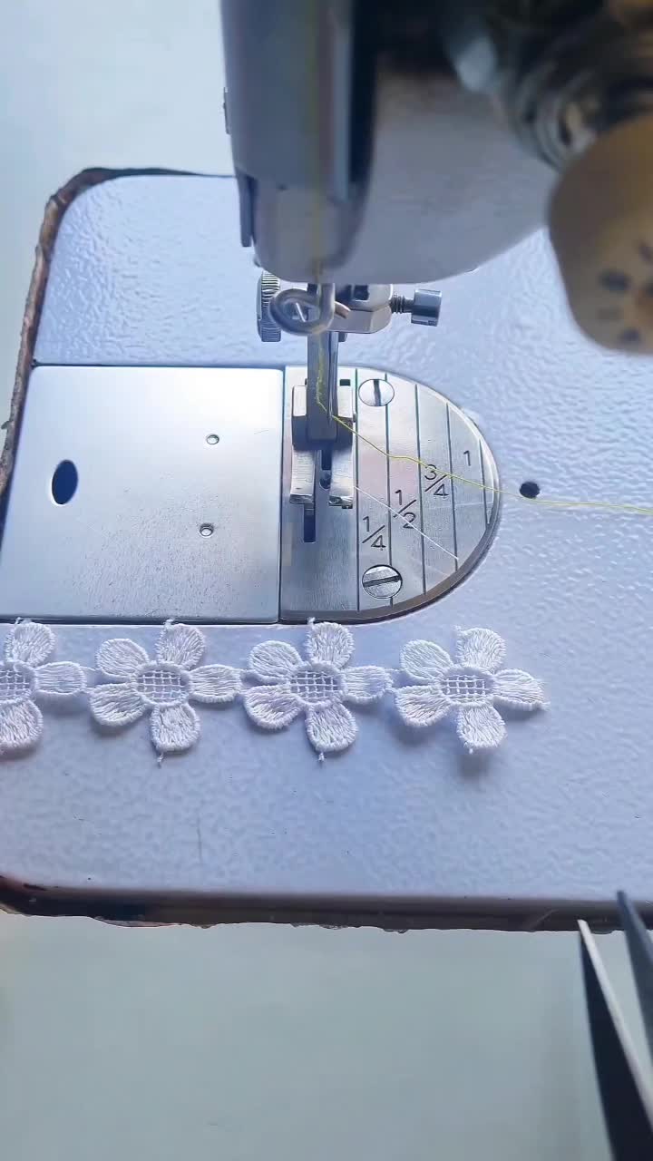 This may contain: a sewing machine with white lace on it