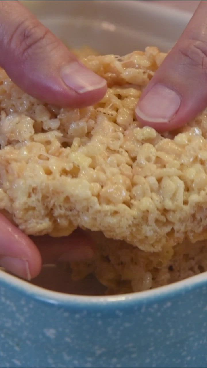 This may contain: two hands reaching for food in a blue bowl with the words how to make rice krispy kreme