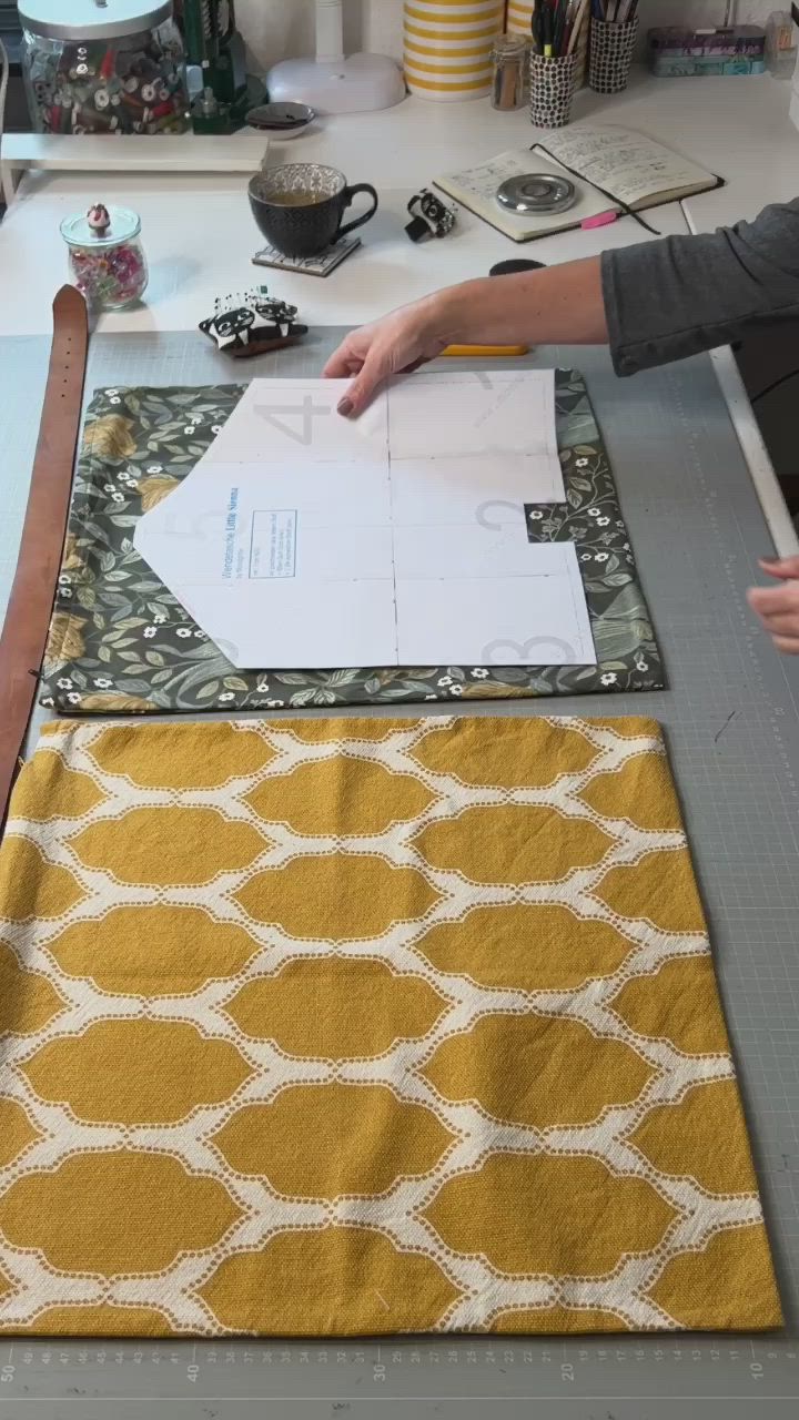 This may contain: a woman is cutting fabric on top of a table with scissors and other crafting supplies