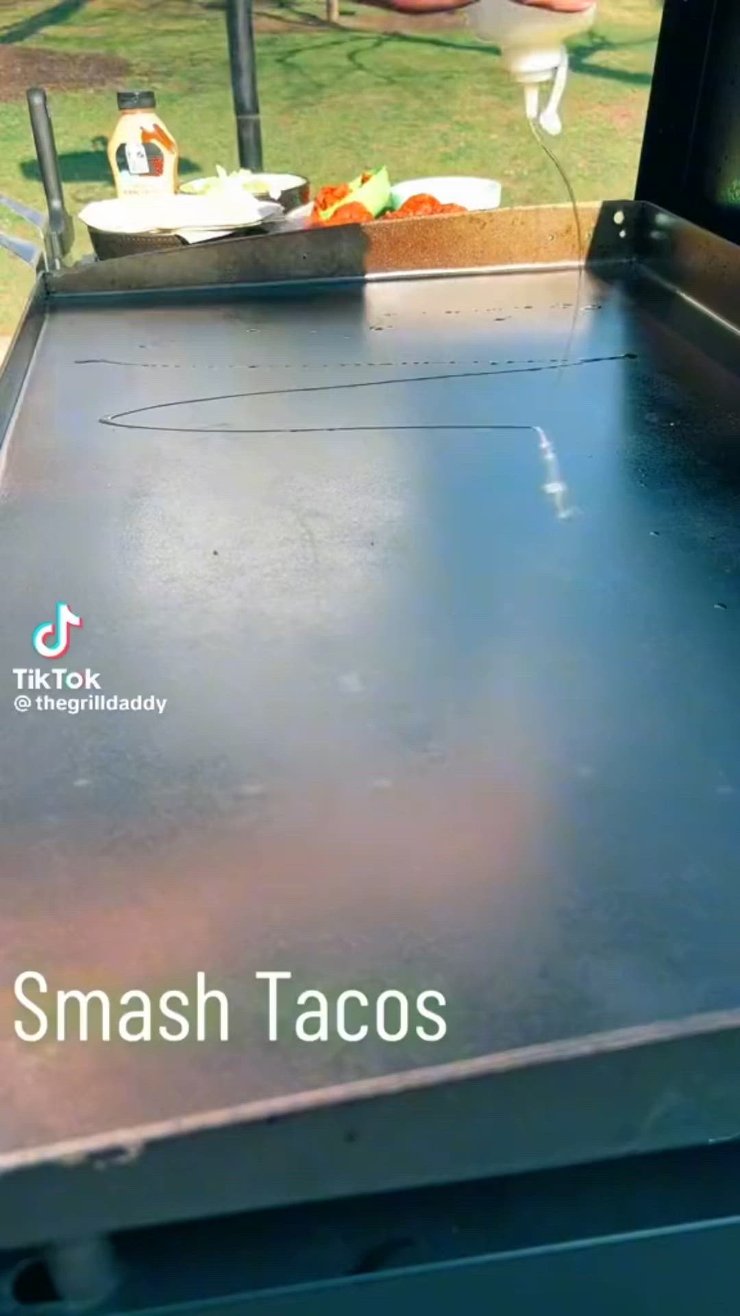 This may contain: there is a black grill with the words smash tacos on it