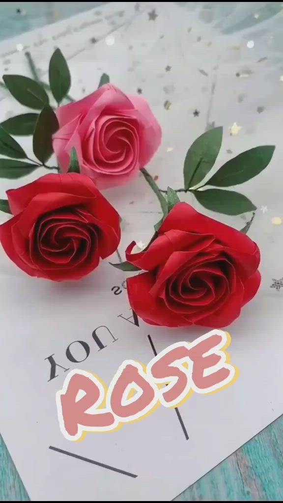 This may contain: three red roses sitting on top of a piece of paper with the word rose in it