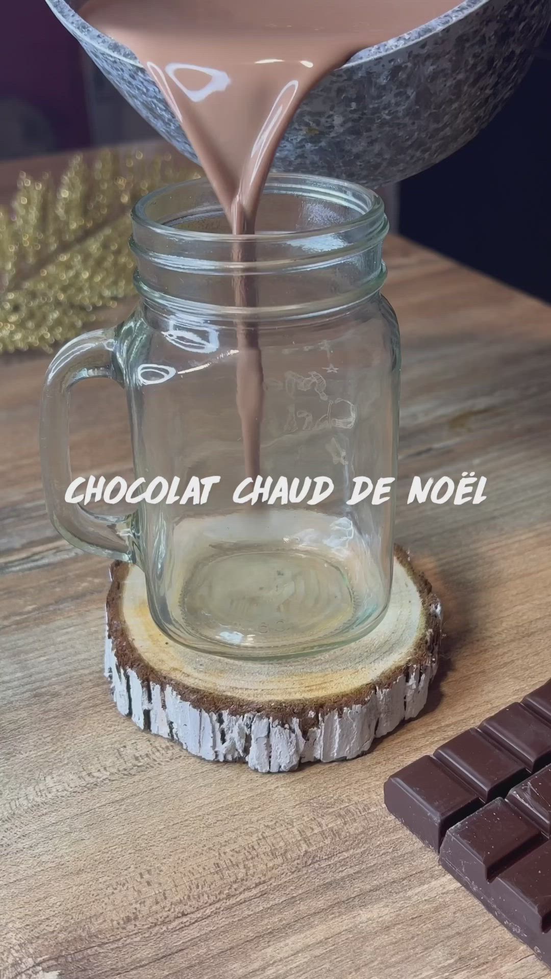 This may contain: chocolate is being poured into a jar on top of a wooden table next to a bar of chocolate