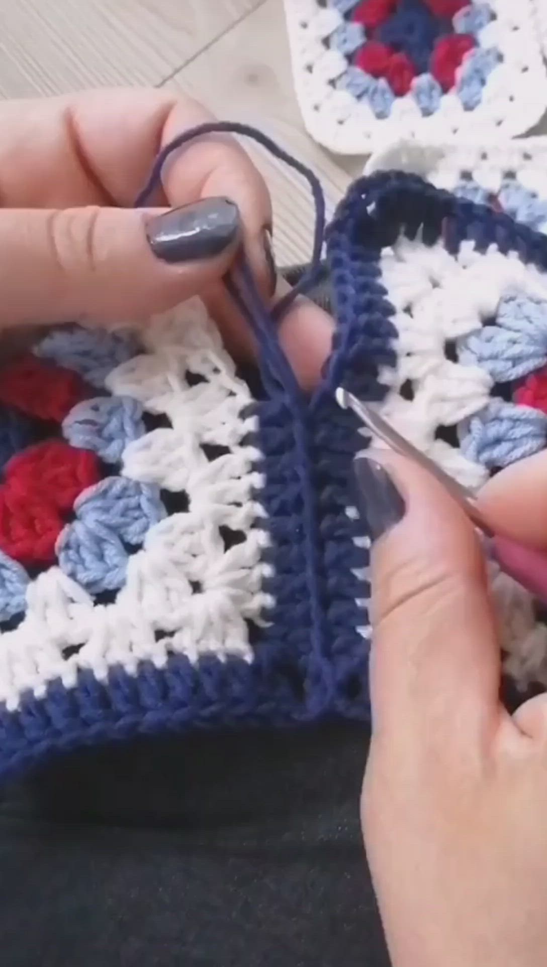 This may contain: someone is crocheting together with scissors and yarn