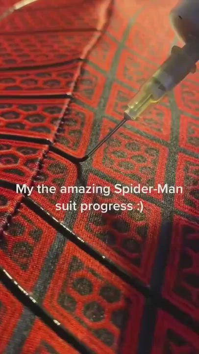 This may contain: an orange and black rug with a needle in it's center, that says my the amazing spider - man suit progress?