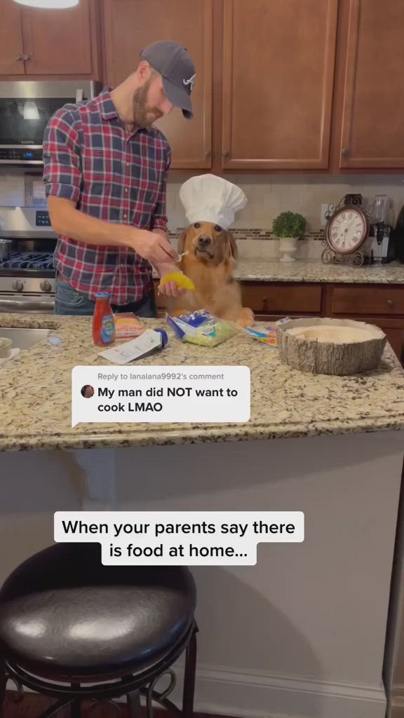 This may contain: a man standing in front of a kitchen counter with a dog sitting on top of it