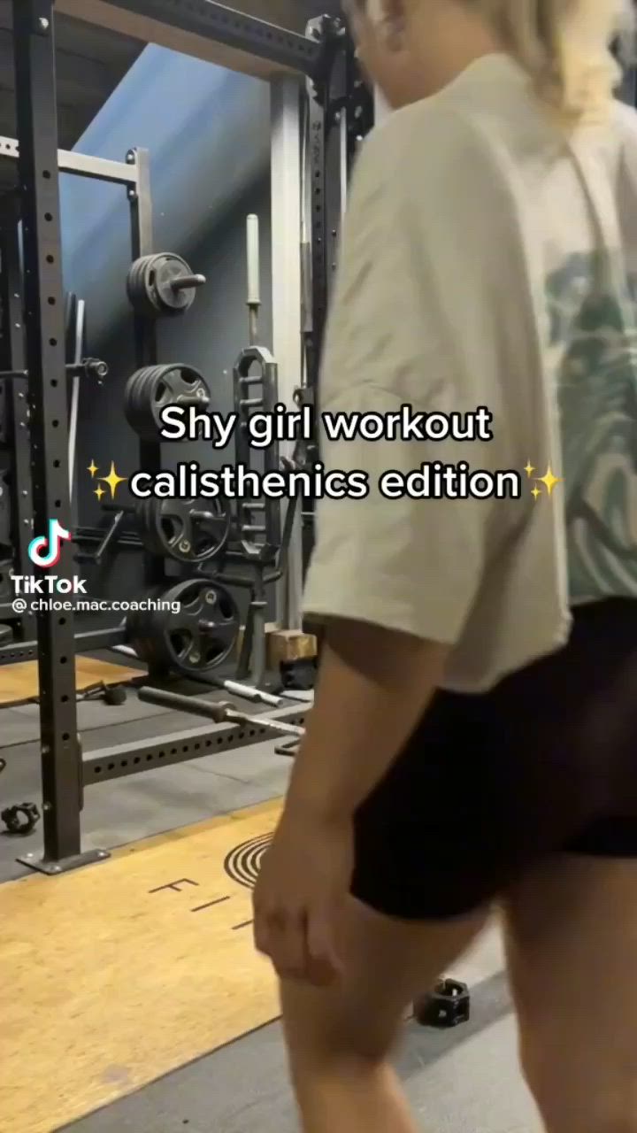 This may contain: a woman is walking in the gym with her back to the camera and text that reads, shy girl workout calistinenes edition
