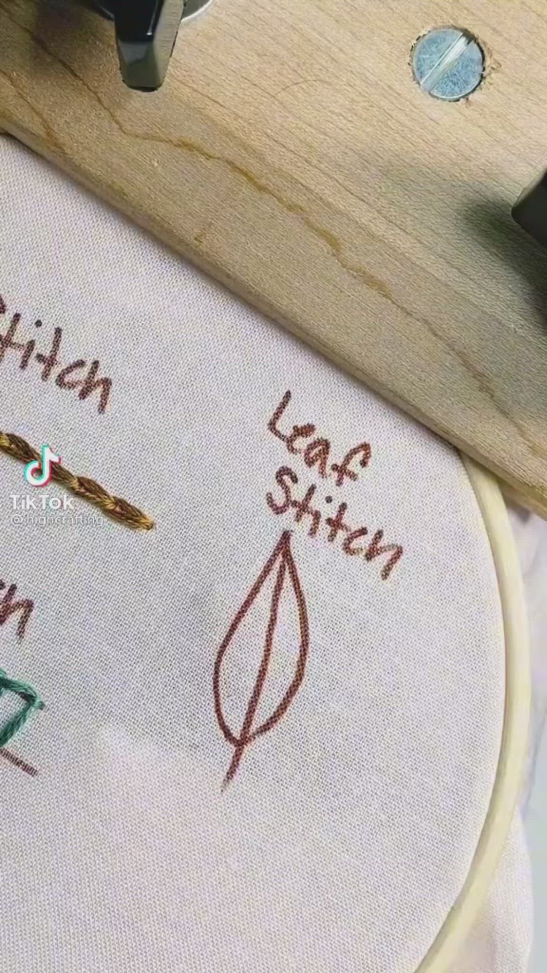 This may contain: a close up of a cross stitch on a piece of wood