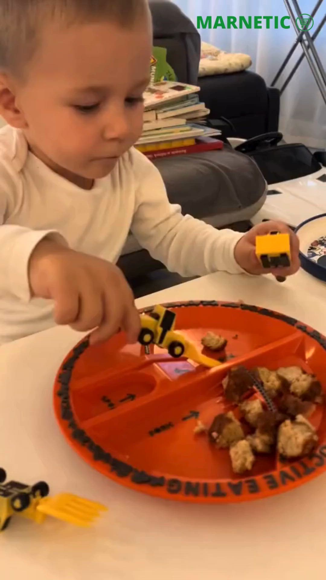 This may contain: a little boy that is sitting at a table with some food in front of him