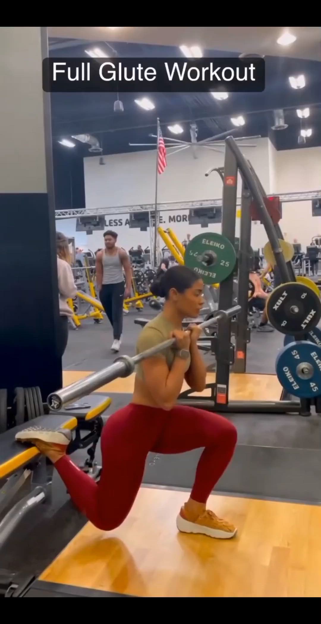 This may contain: a woman squats down while holding a barbell