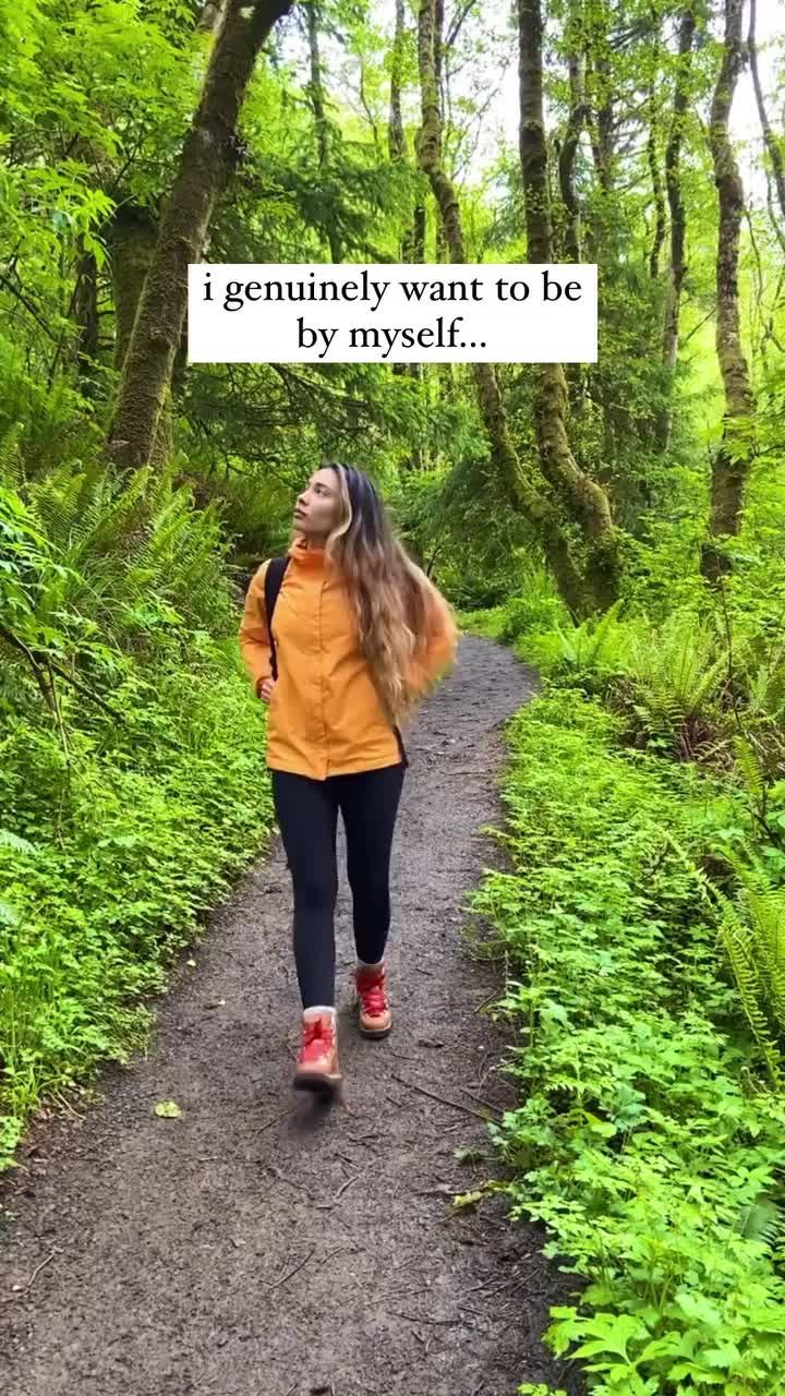 This may contain: a woman walking down a path in the woods with a sign above her head that says, i gently want to be by yourself